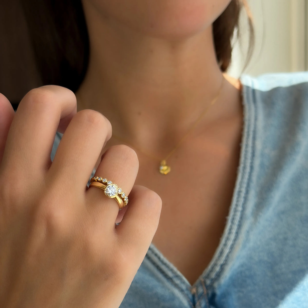 Close-up van Lily en Luna ringen met lab-grown diamanten gedragen aan de hand.